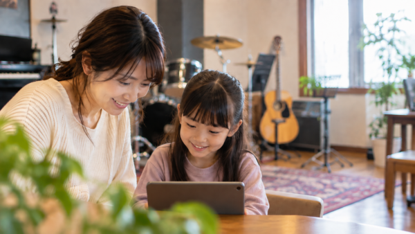 音楽教室でタブレットを見ながら親子でレッスンを検討する様子